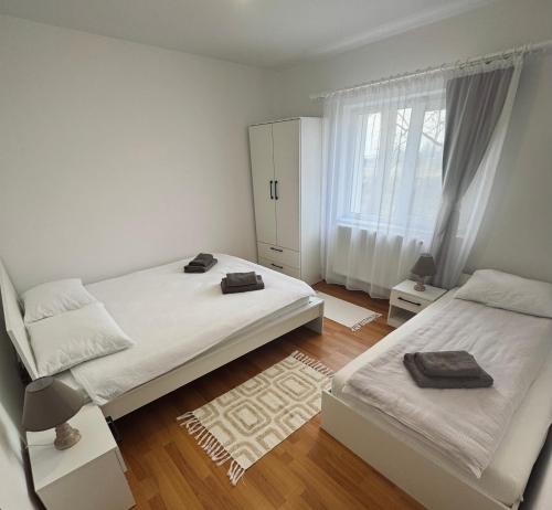 a bedroom with two beds and a window at Edge Apartament in Cristuru Secuiesc