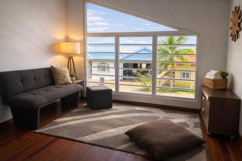 a living room with a couch and a large window at Maison Meredith in Paramaribo