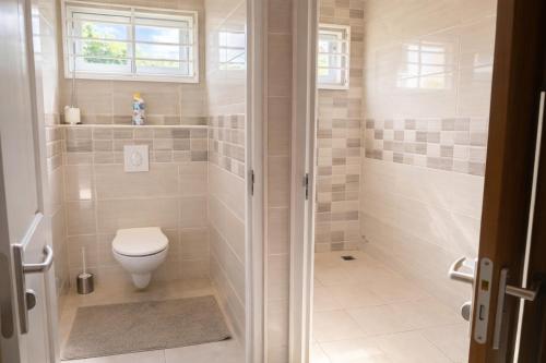 ein Badezimmer mit Toilette und Dusche in der Unterkunft Maison Meredith in Paramaribo