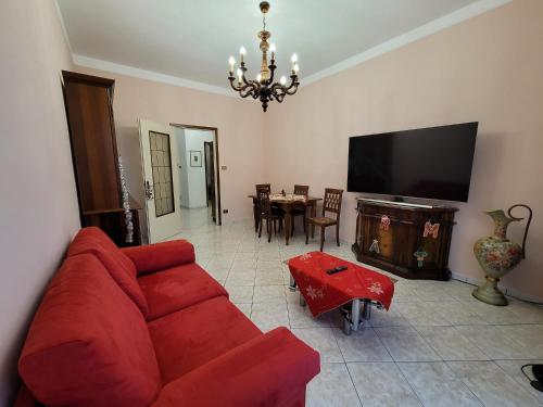 een woonkamer met een rode bank en een televisie bij Appartamento Galileo Ferraris, in Vercelli