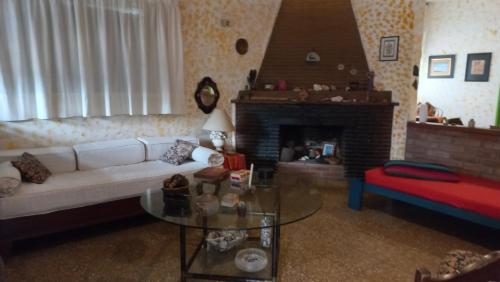a living room with a white couch and a fireplace at La casa de los titiriteros in Mina Clavero