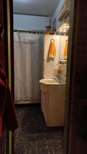 a bathroom with a sink and a shower curtain at La casa de los titiriteros in Mina Clavero