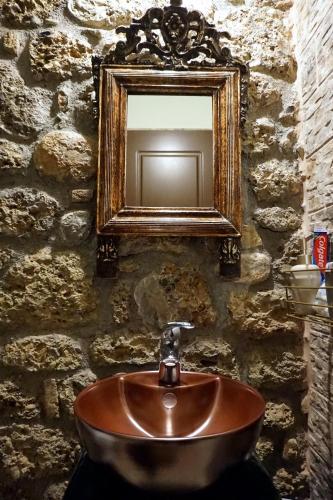 ein Waschbecken in einem Steinbadezimmer mit Spiegel in der Unterkunft Ξενώνας Αστερωδή in Synikia Mesi Trikalon
