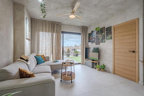 a living room with a couch and a ceiling fan at Paraiso Terrace Suite in Playa Paraiso