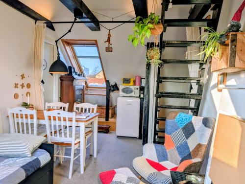 a living room with a table and chairs and a ladder at Cozy Haven CPH - Bright small rooms, easy public transport in Copenhagen