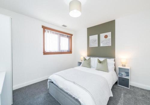 a bedroom with a large white bed and a window at Charming 2-Bedroom House in Boddam by CMC Stays in Boddam