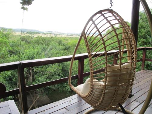 塞拉纳镇Cabaña Los Pololos的门廊上摆着一把摇椅，可以眺望森林。
