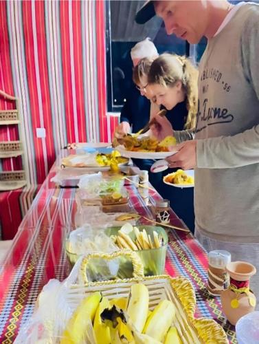 eine Gruppe von Menschen, die um ein Buffet mit Speisen stehen in der Unterkunft Rum Desert Life Bubble Experience in Wadi Rum
