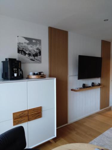 een woonkamer met een televisie en een witte kast bij Goldstück in Oberstdorf
