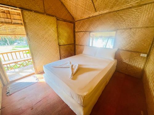 a small bedroom with a bed with a towel on it at Wooden House Koh Lanta in Ko Lanta
