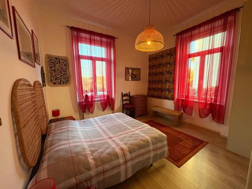 een slaapkamer met een bed en twee ramen bij Il Gelsomino "Meraviglioso appartamento in villa Liberty" in Gorizia