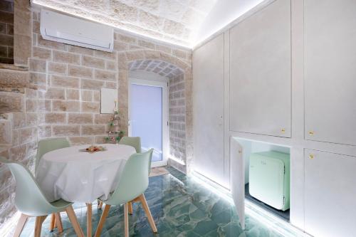 una sala da pranzo con tavolo e sedie bianchi di Stella Marina a Molfetta