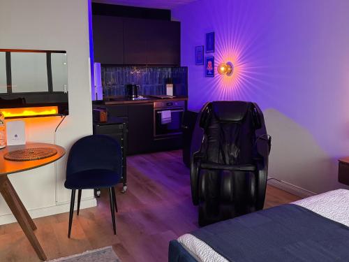una camera con letto e una cucina con illuminazione viola di CuxHeaven - modernes Studio-Apartment direkt am Meer mit Pool, Sauna und Massage a Cuxhaven
