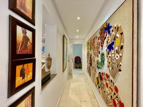 ein Flur mit Gemälden an den Wänden und Bildern an der Wand in der Unterkunft Le Chesterfield Gammarth in Gammarth