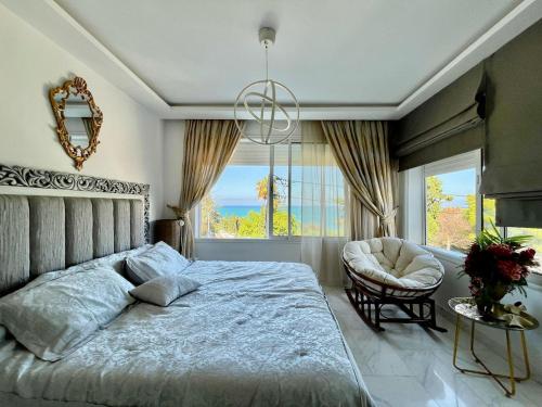 Le Chesterfield Gammarth في قمرت: غرفة نوم بها سرير وكرسي ونافذة