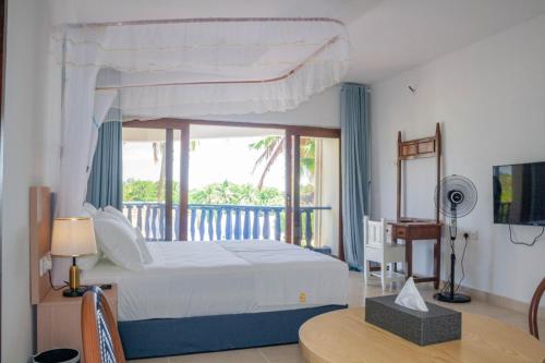 une chambre avec un grand lit et un balcon dans l'établissement Diani Sands International Hotel, à Galu