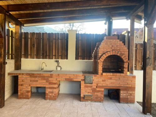 a outdoor kitchen with a sink and a brick oven at Casă chic La Han la Slănic in Slănic-Moldova