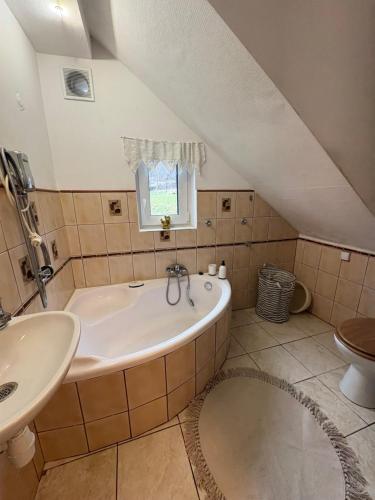 een badkamer met een bad en een wastafel bij Dom w górach Zacisze lasu in Sucha Beskidzka