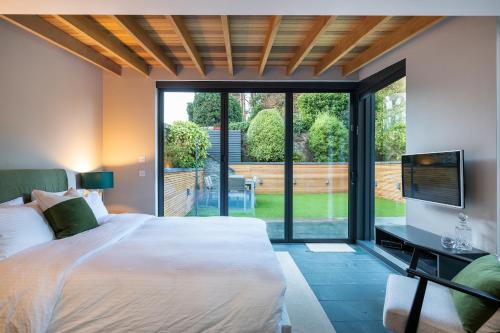 a bedroom with a large bed and a sliding glass door at Garden Rooms Edinburgh in Edinburgh
