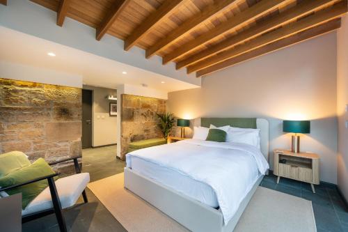 a bedroom with a white bed and a stone wall at Garden Rooms Edinburgh in Edinburgh