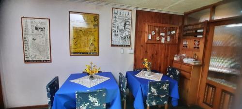 una sala da pranzo con due tavoli e sedie blu di Hosteria Quellon a Quellón
