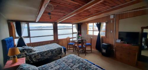 una camera con due letti, un tavolo e un divano di Hosteria Quellon a Quellón