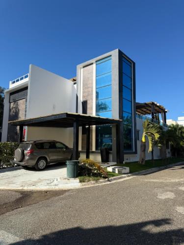 een auto geparkeerd op een parkeerplaats voor een gebouw bij Caribbean getaway Villa 30 in Puerto Plata