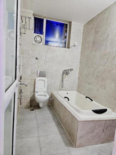a bathroom with a tub and a toilet and a sink at The Inspira Hotel Haridwar in Haridwār