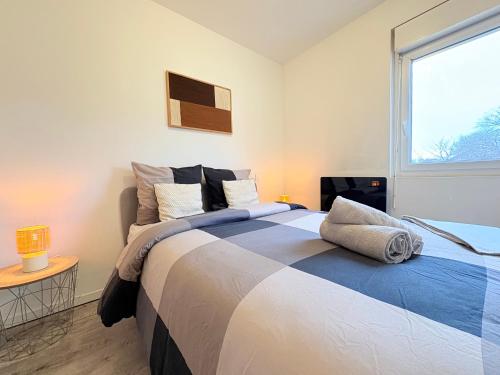 une chambre avec un grand lit et une fenêtre dans l'établissement Le Faubourg, à Pamiers