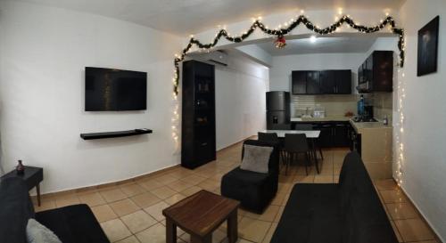 un salon avec une table et des chaises et une cuisine dans l'établissement Casa Héroes, à Cancún