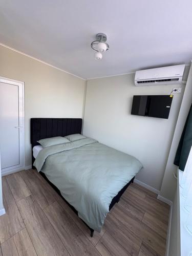 a small bedroom with a bed and a tv at Atelier SkyLine in Gabrovo