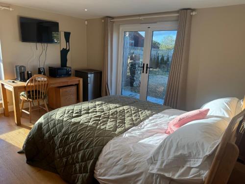 a bedroom with a bed and a desk and a window at Pine Ridge 1 in Bristol