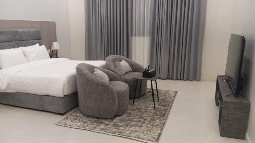 une chambre avec un lit, une chaise et une télévision dans l'établissement luxury royal apartments, à Quai
