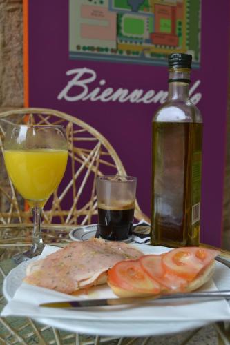 Una mesa con un plato de comida y una botella de vino. en Lantana Garden, en Pilas