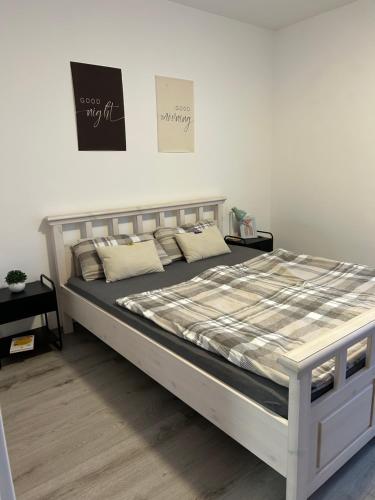 een bed in een witte kamer met een bedframe bij MelsHome Apartment mit 2 Schlafzimmer in Geislingen an der Steige