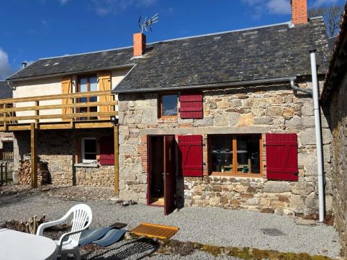 ein altes Steinhaus mit roten Rollläden darauf in der Unterkunft Maison typique Auvergne in Montel-de-Gelat