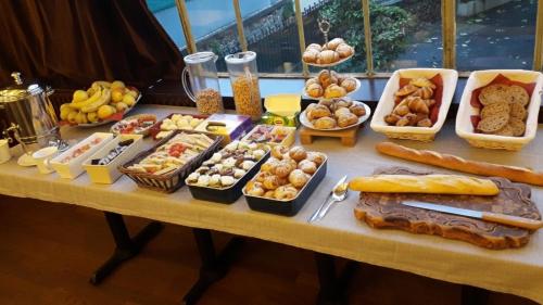 een tafel met veel verschillende soorten voedsel erop bij Hôtel Belleville in Lamalou-les-Bains