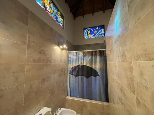 een badkamer met een douche en een paraplu. bij Bosque y Playa en casa in Carilo