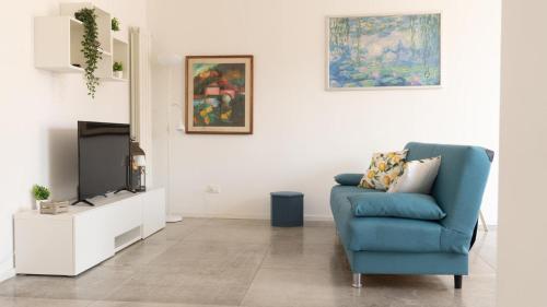 een woonkamer met een blauwe stoel en een tv bij Aerial House in Palermo