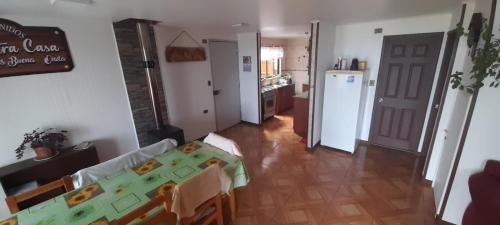 ein Wohnzimmer mit Tisch und Küche in der Unterkunft Casa en la playa in Valdivia