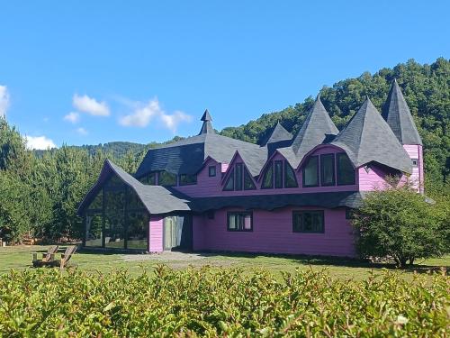 a pink house with a gambrel roof at Spectra Lodge Boutique Hotel in Malalcahuello