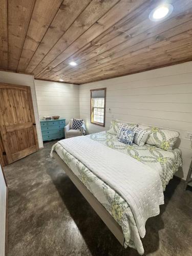 een slaapkamer met een bed en een houten plafond bij Willow Oak Cottage in Fort Payne