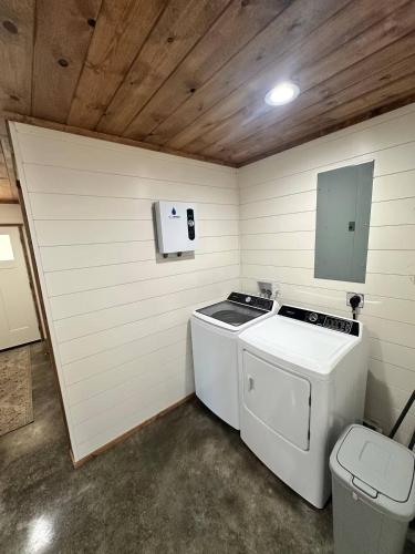 een wasmachine en droger in een kamer met een toilet bij Willow Oak Cottage in Fort Payne