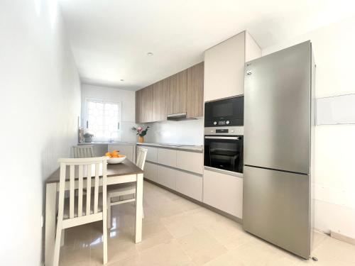 a kitchen with a table and a stainless steel refrigerator at Penthouse Jul&Mel in Valle Gran Rey