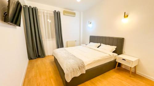 a bedroom with a bed with a black headboard and a window at Zarii Suites- Cotroceni in Bucharest