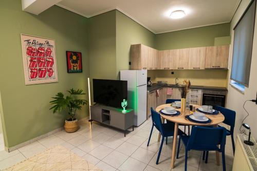eine Küche mit einem Tisch mit Stühlen und einem TV in der Unterkunft Iria's Cozy House 2 in Sparta