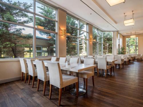 a dining room with a table and chairs and windows at WOW Airport Hotel in Istanbul