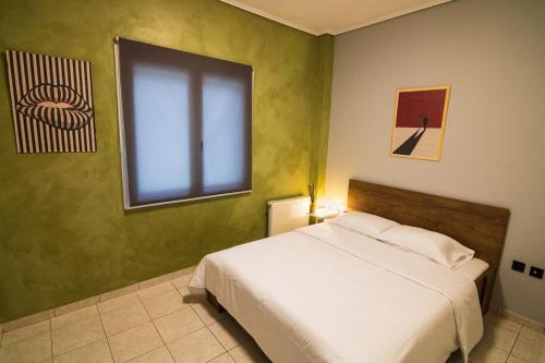 ein Schlafzimmer mit einem weißen Bett und einem Fenster in der Unterkunft Iria's Cozy House 2 in Sparta