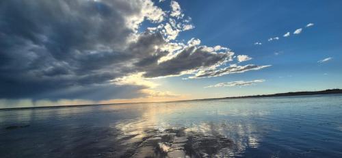 un grand volume d'eau avec un ciel nuageux dans l'établissement Luxury Lodge Costa Blanca, à San Antonio Oeste