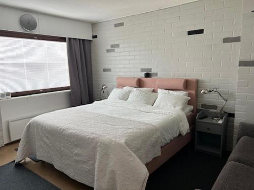 a bedroom with a large bed and a window at Kangaskartano in Keitelepohja
